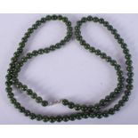 A CARVED SPINACH JADE NECKLACE. 78 cm long.