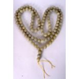 A LONG CARVED CHINESE JADE NECKLACE, formed with spherical beads. 184 cm long.