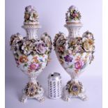 A LARGE PAIR OF 19TH CENTURY GERMAN PORCELAIN VASES AND COVERS painted with flowers. 43 cm x 16 cm.