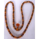 A TIBETAN AMBER TYPE NECKLACE, spherical in form with inlaid beads. 104 cm long.