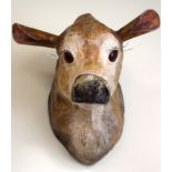 A PAPIERMACHE BUST OF A COW, formed with bulging, glaring eyes. 32 cm x 33 cm.