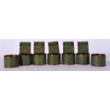 A SET OF TWELVE THAI ENAMELLED BRASS NAPKIN RING HOLDERS, decorated with buddhistic figures amongst