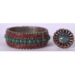 A TIBETAN WHITE METAL CORAL INSET BANGLE, together with a matching ring. Bangle 8 cm wide. (2)