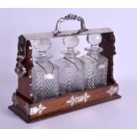 AN EDWARDIAN SILVER PLATED OAK THREE BOTTLE TANTALUS Daniel & Artur, with solid silver decanter lab