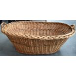 A VINTAGE WICKER BASKET, formed with thick twin handles. 95 cm wide.