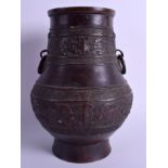 A 19TH CENTURY CHINESE TWIN HANDLED BRONZE VASE Qing, decorated with mask heads and vines. 25 cm x