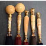 A GROUP OF FIVE ANTIQUE IVORY UMBRELLAS, formed with later yellow metal mounts, of varying design.