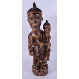 AN EARLY 20TH CENTURY AFRICAN TRIBAL POLYCHROMED MATERNITY FIGURE decorated with triangular motifs.