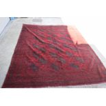 A LARGE RED GROUND AFGHAN RUG, decorated with symbols and motifs.316 cm x 250 cm.