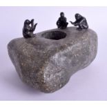AN UNUSUAL BRONZE AND HARDSTONE FIGURAL GROUP modelled with three figures seated around a fire. 17