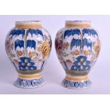 A PAIR OF 18TH CENTURY DUTCH DELFT POLYCHROME VASES painted with floral sprays. 16 cm high.