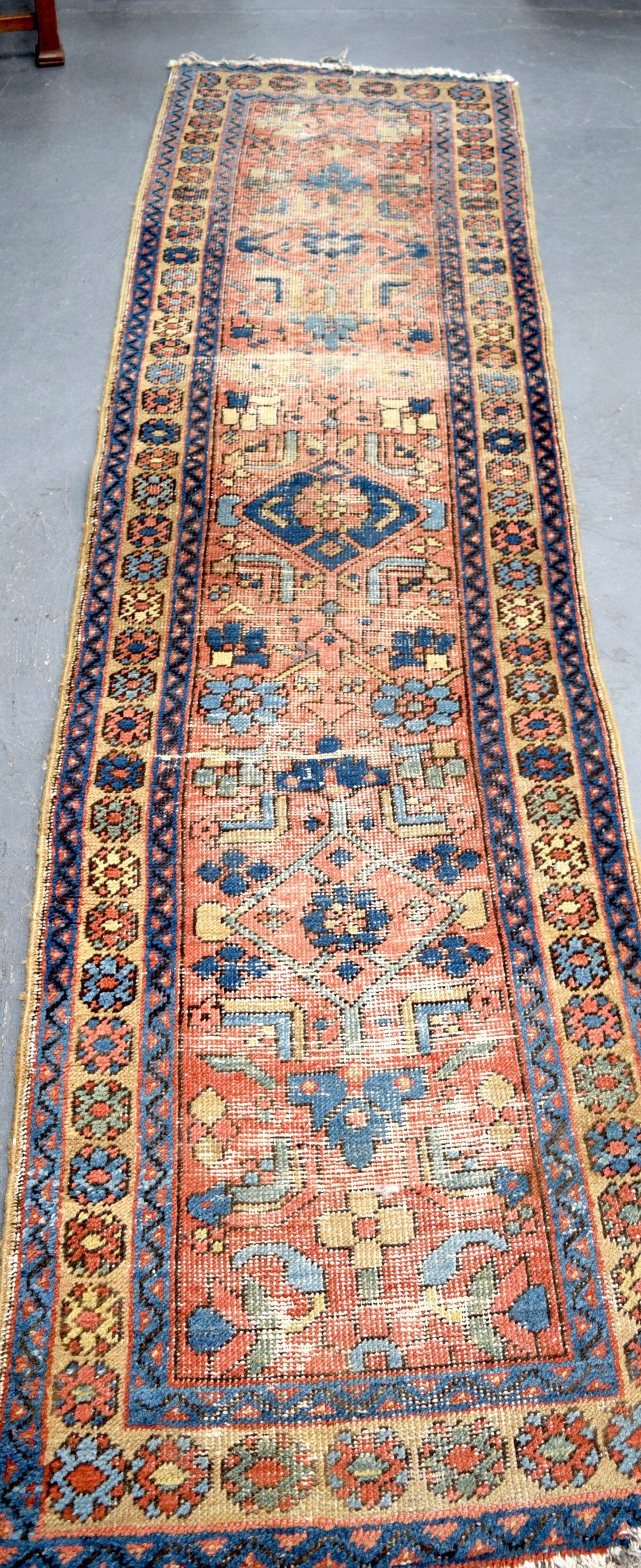 AN EARLY 20TH CENTURY RUNNER RUG, decorated with foliage. 258 cm x 70 cm.