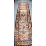 AN EARLY 20TH CENTURY RUNNER RUG, decorated with foliage. 258 cm x 70 cm.