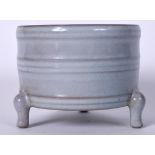 A CHINESE PALE GLAZED POTTERY CENSER, formed tri legged with ribbed body. 11 cm wide.