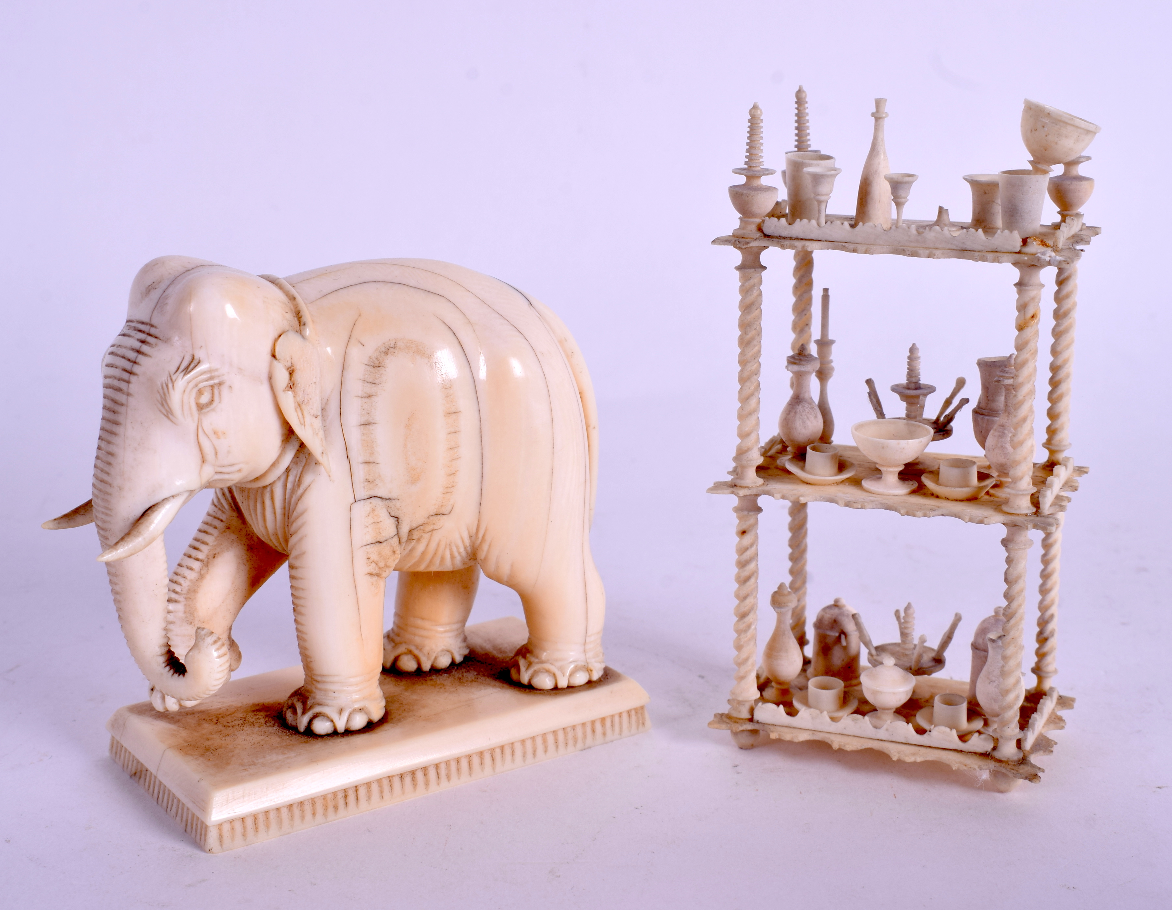 A 19TH CENTURY INDIAN CARVED IVORY ELEPHANT together with a carved bone prisoner of war dumb waiter