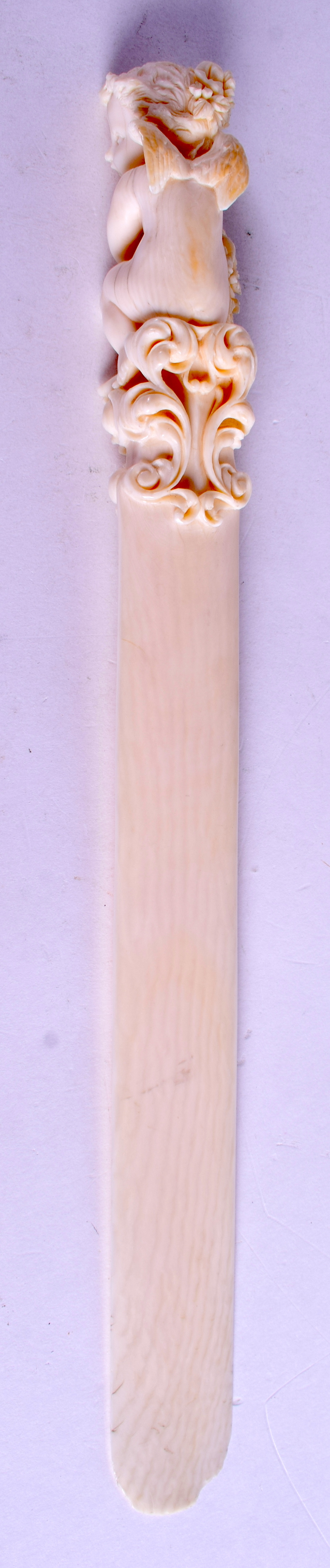 A GOOD 19TH CENTURY EUROPEAN DIEPPE IVORY LETTER OPENER carved with a putti holding foliage. 30 cm - Image 2 of 3