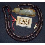 A CHINESE MUTTON JADE BELT HOOK, together with a wooden necklace with a carved ivory pendant. (2)