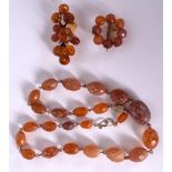 AN AMBER BROOCH IN THE FORM OF A FLORAL SPRIG, together with another and a similar necklace. Neckla