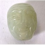 AN EARLY 20TH CENTURY CHINESE GREEN JADE TOGGLE IN THE FORM OF BUDDHA, modeled grinning. 2.75 cm.
