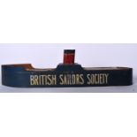 A VINTAGE BRITISH SAILOR'S SOCIETY MONEY BOX IN THE FORM OF A SHIP, formed with various paper label