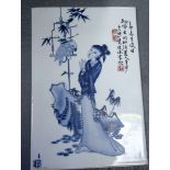 A 20TH CENTURY CHINESE BLUE AND WHITE PORCELAIN PANEL, depicting a female with a bird. 25.5 cm x 17