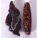 A CARVED AGATE PENDANT IN THE FORM OF A STYLISED FEMALE, together with a zhu bead. (2)