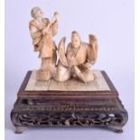 A 19TH CENTURY JAPANESE MEIJI PERIOD CARVED IVORY OKIMONO modelled as two performers upon a mat. Iv
