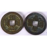 TWO CHINESE BRONZE COINS, decorated in relief with calligraphy 6 cm wide.