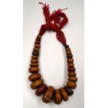 A MORROCAN AMBER NECKLACE, formed with flattened beads. 54 cm long.
