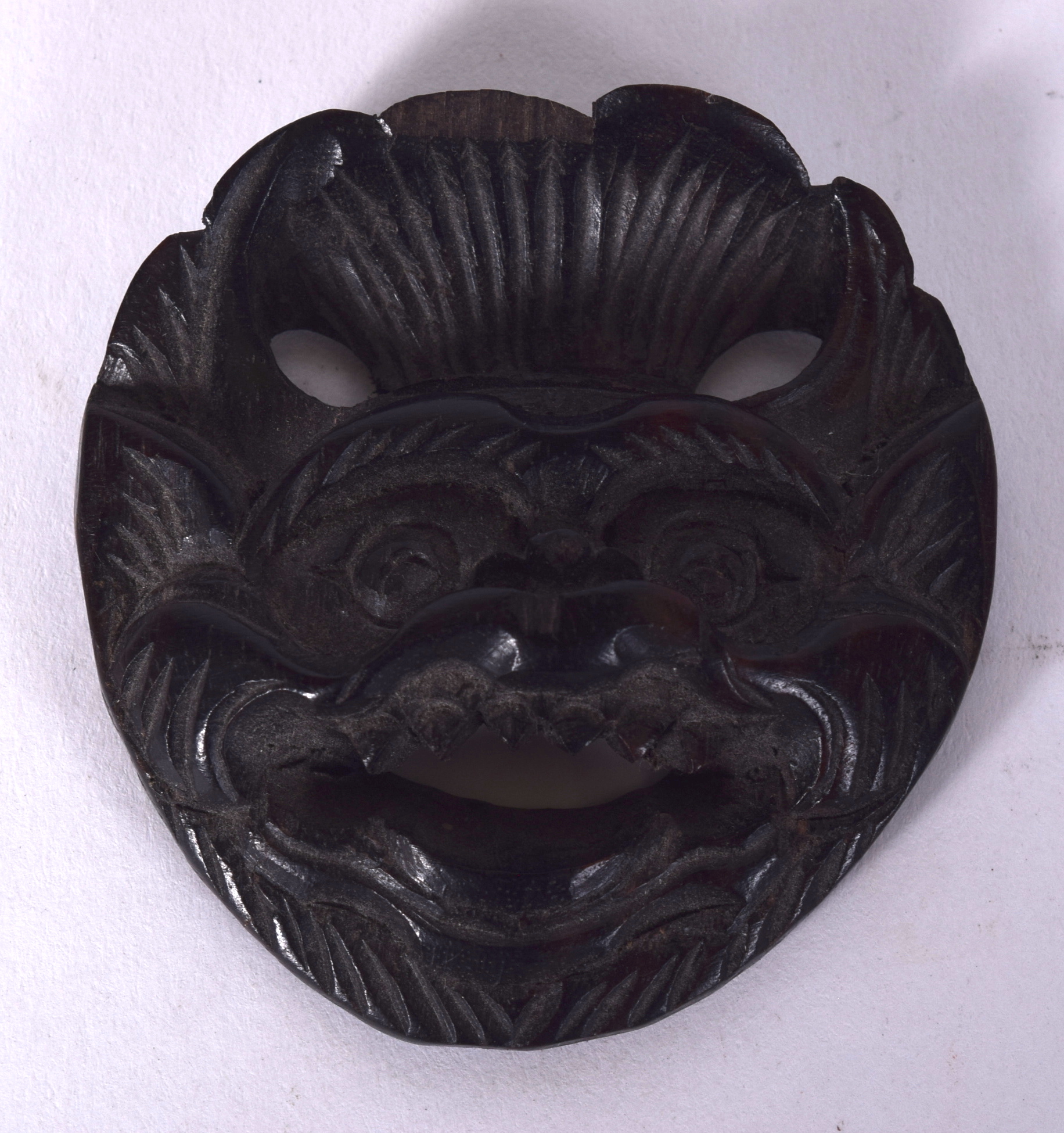 AN EARLY 20TH CENTURY CHINESE HARDWOOD BELT BUCKLE, in the form of a snarling demon. 5.2 cm x 4.8 c