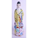 AN EARLY 20TH CENTURY CHINESE FAMILLE JAUNE PORCELAIN FIGURE modelled upon clouds. 27 cm high.