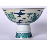 A 20TH CENTURY CHINESE PORCELAIN STEM CUP, decorated with mythical beasts amongst the clouds. 16 cm