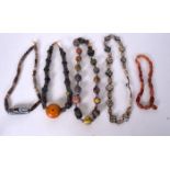 AN EARLY 20TH CENTURY BANDED AGATE NECKLACE, together with four other eastern necklaces of varying