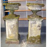 A LARGE PAIR OF ANTIQUE COMPOSITION GARDEN URN ON STAND. 136 cm x 49 cm.