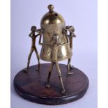 AN UNUSUAL AFRICAN BRASS FIGURE OF THREE MALES modelled holding aloft a bell. 18 cm x 12 cm.