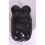 A CARVED WOODEN FIGURAL PENDANT, in the form of two figures locking lips in an embrace, 7 cm long.