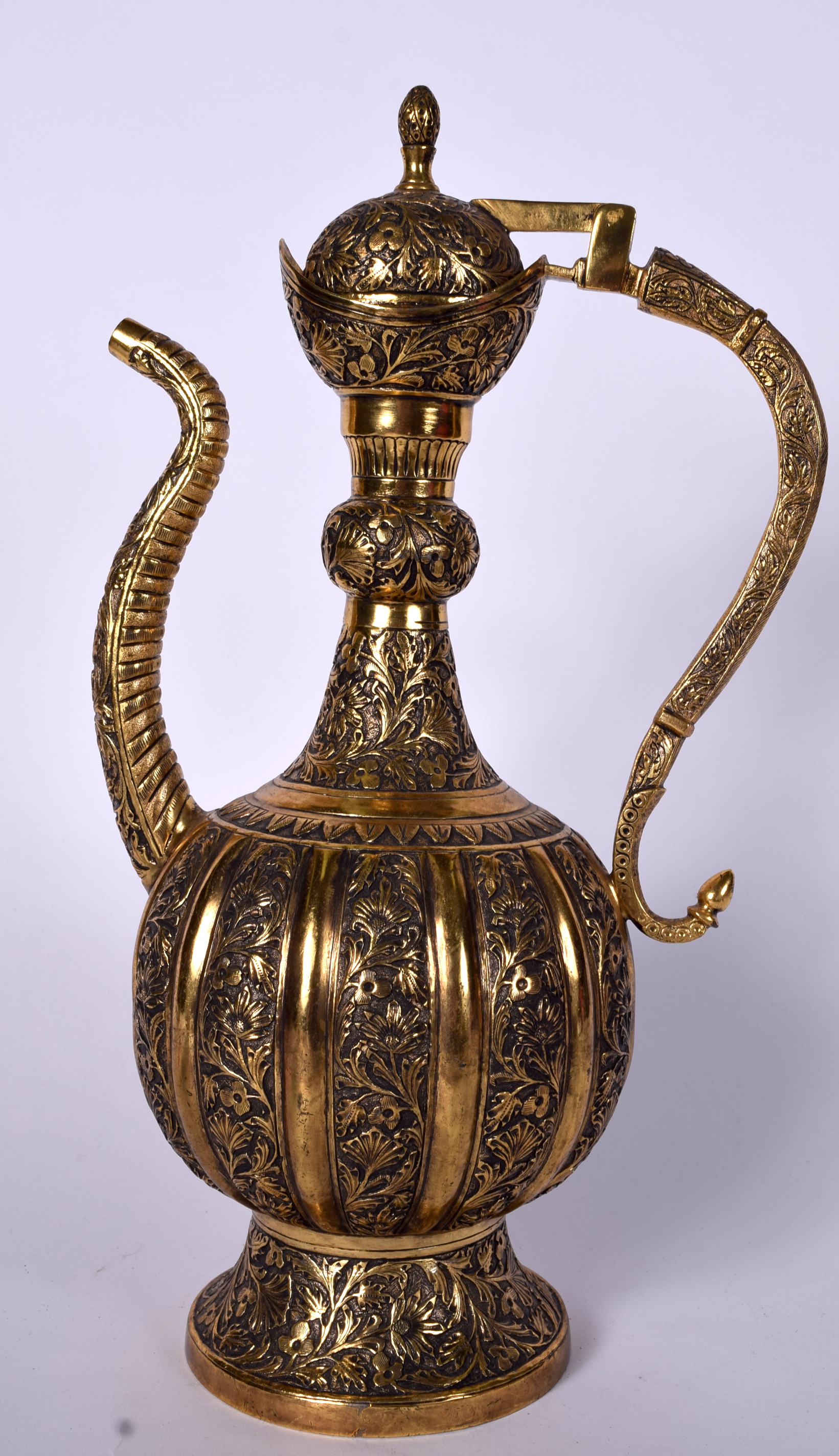 A LARGE ISLAMIC OR PERSIAN GILT BRONZE EWER, decorated with extensive foliage and artichoke finial.