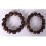A PAIR OF CHINESE CARVED WOODEN BRACELET, formed with spherical beads. 9 cm wide.