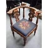 AN ANTIQUE ITALIAN HEAVILY CARVED OAK CORNER CHAIR, the supports formed as griffins and the top wit