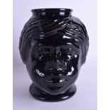 A RARE AMERICAN 1920S MOULDED BLACK GLASS COOKIE JAR in the form of a female wearing hooped earring