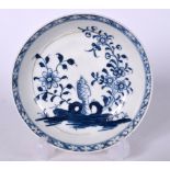 AN 18TH CENTURY LIVERPOOL BLUE AND WHITE PORCELAIN SAUCER, decorated with flowering rock. 12 cm wid