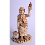 A 19TH CENTURY JAPANESE MEIJI PERIOD CARVED IVORY OKIMONO modelled as a Buddhistic male upon a natu