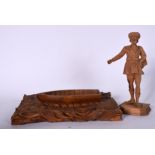 A CARVED WOODEN FIGURE OF A STANDING MALE, together with a boat carving. Male 24.5 cm high. (2)