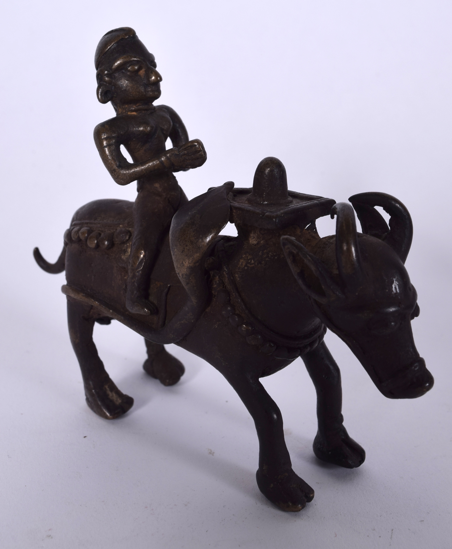 AN INDIAN BRONZE STATUE, formed as a male upon the back of an oxon. 12.5 cm wide.