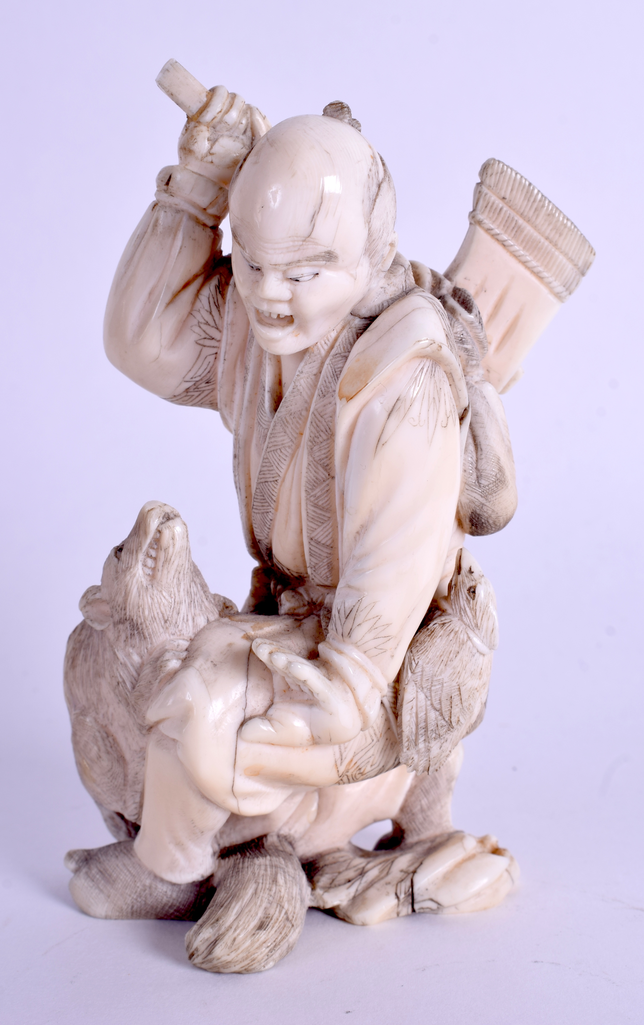 A 19TH CENTURY JAPANESE MEIJI PERIOD CARVED IVORY OKIMONO modelled as a male holding an axe. 11 cm