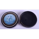 A MID 19TH CENTURY CARVED IVORY AND EBONY SNUFF BOX painted with a classical scene. 8 cm diameter,.