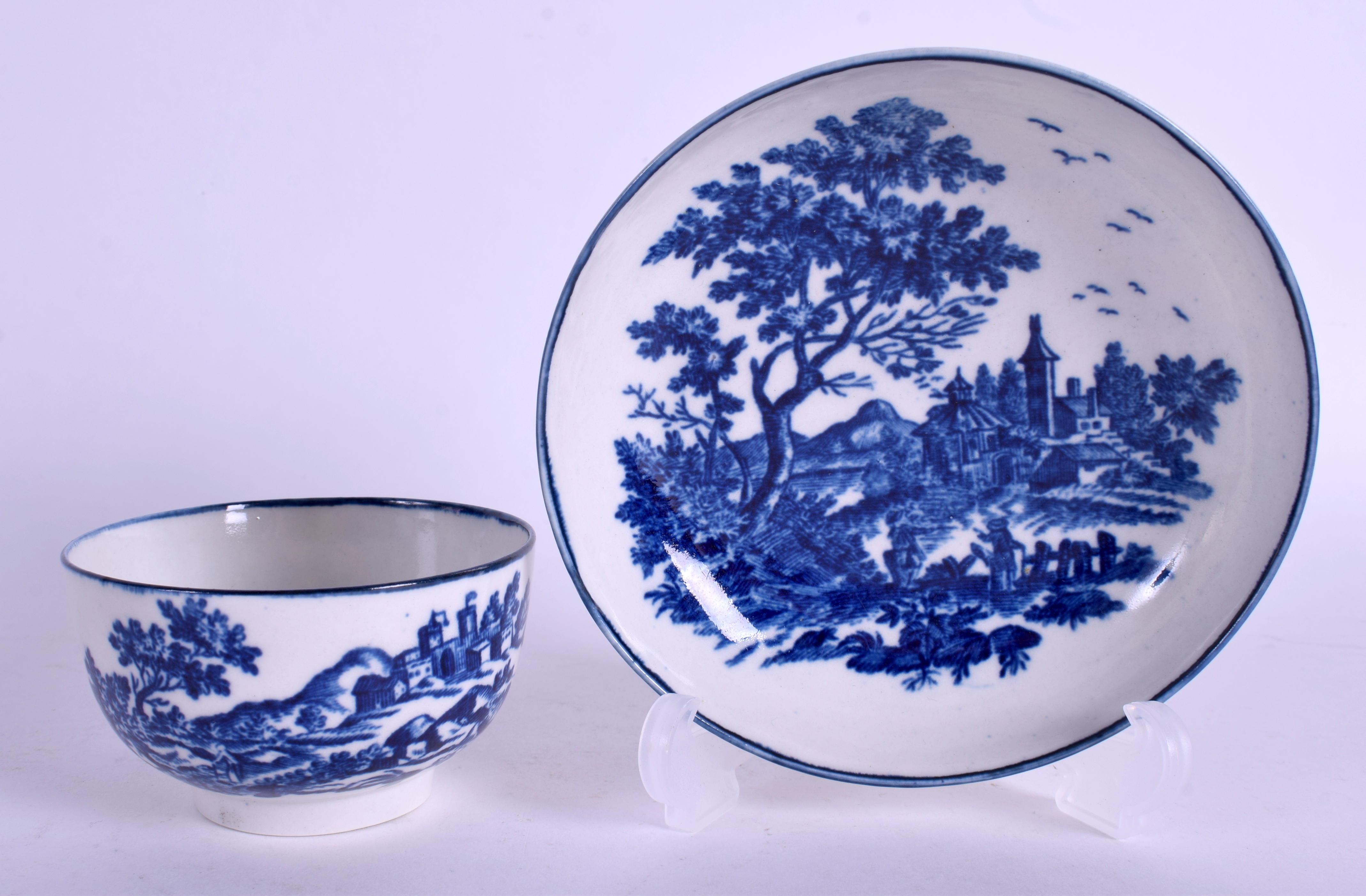 AN 18TH CENTURY WORCESTER TEA BOWL AND SAUCER printed with European landscapes. 11 cm wide. (2)