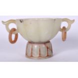 A CHINESE TWIN HANDLED JADE BOWL ON STAND, formed with a ribbed body. 14.5 cm wide.
