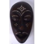 AN AFRICAN CARVED HARDWOOD TRIBAL MASK, inset with mother of pearl decoration. 33 cm x 19 cm.