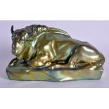 AN UNUSUAL HUNGARIAN ZSOLNAY PECS LUSTRE FIGURE OF A BULL modelled recumbent. 22 cm x 11 cm.